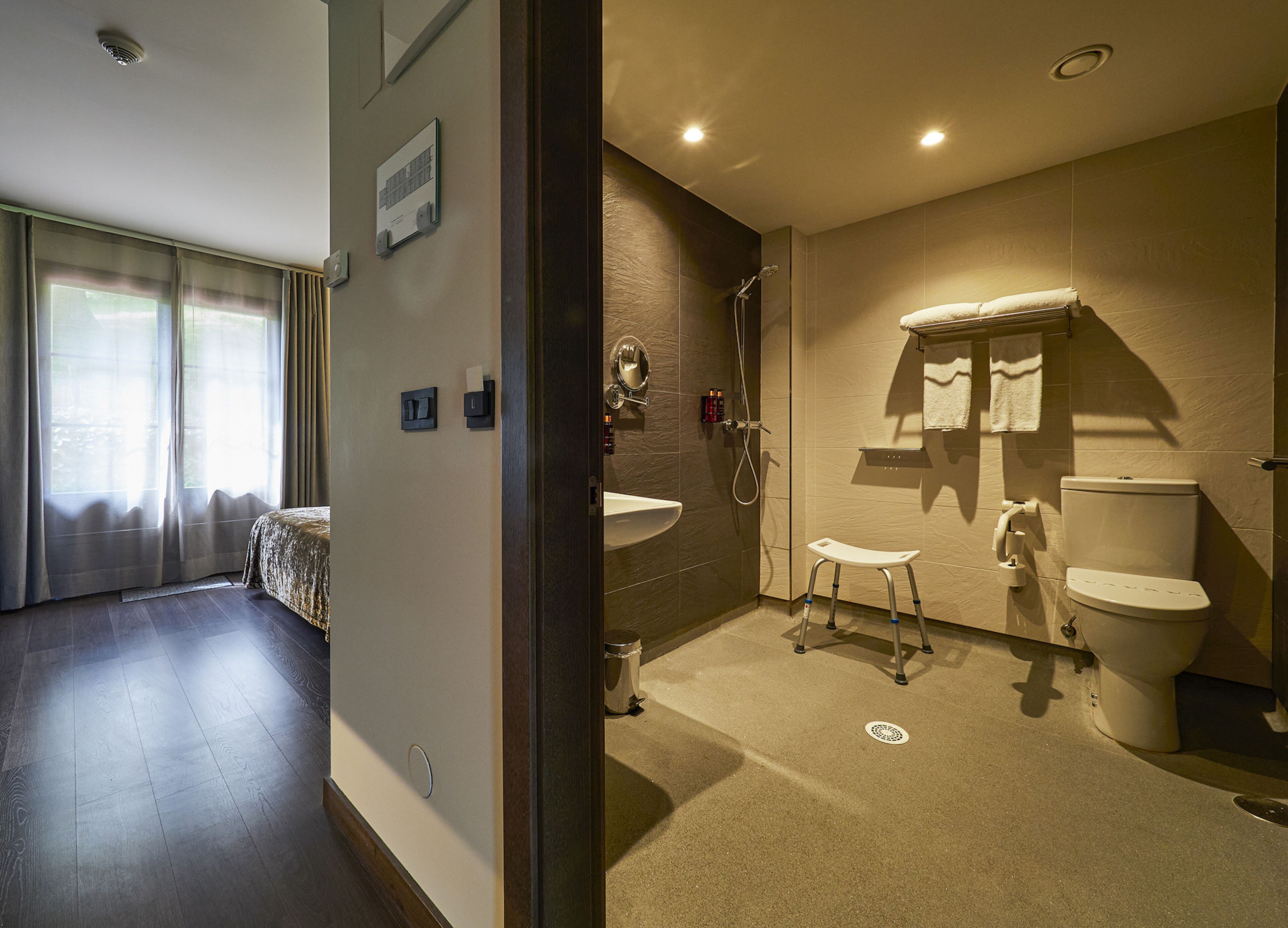 A modern bathroom with a shower, toilet, and sink.