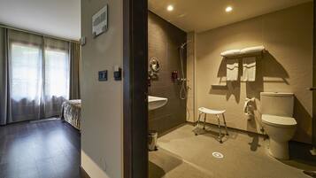 A modern bathroom with a shower, toilet, and sink.
