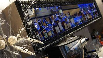 Zona de bar con un espejo que refleja botellas y una máquina de café.