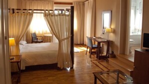 Una habitación de hotel con cama, escritorio, silla, mesa y televisor.