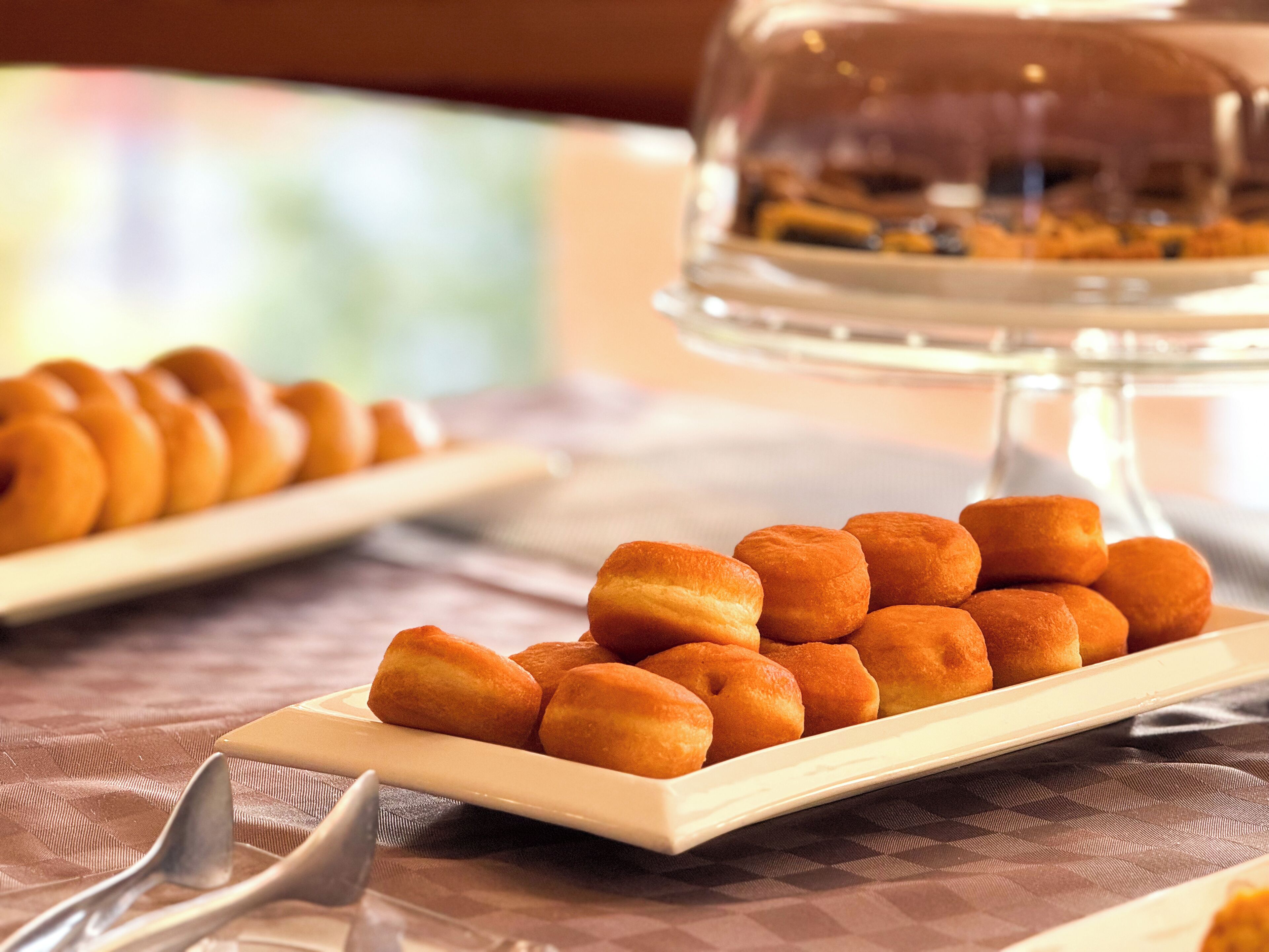 Una mesa de buffet con una variedad de pasteles y una vitrina en el fondo.
