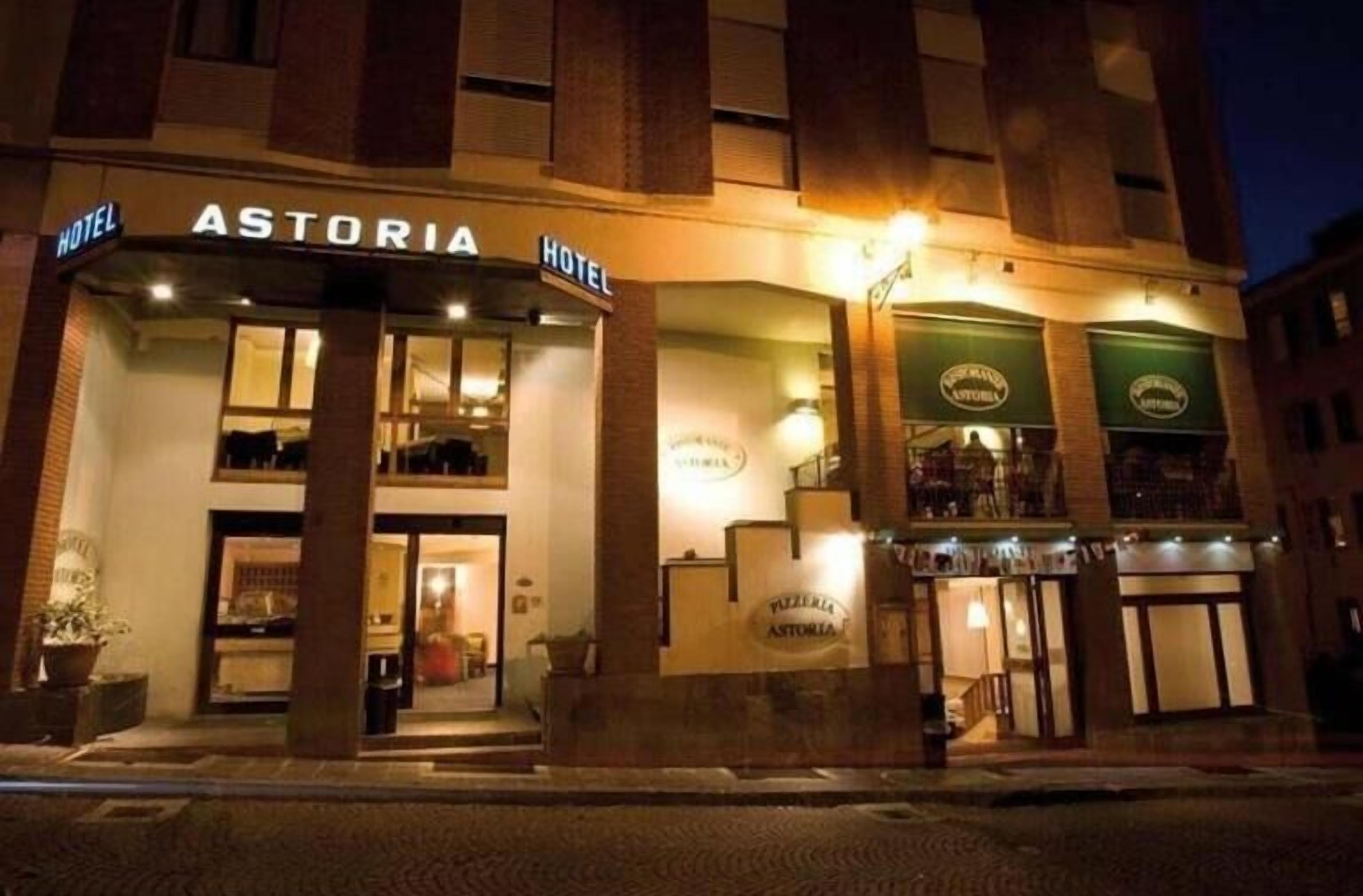 Un hotel llamado ASTORIA con una entrada destacada y un letrero que indica que es un hotel.