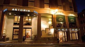 Un hotel llamado ASTORIA con una entrada destacada y un letrero que indica que es un hotel.