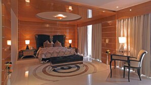 Un dormitorio moderno con una cama grande, dos mesitas de noche, un escritorio y una silla.