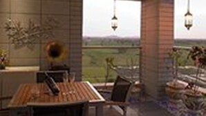 Un comedor moderno con una mesa y sillas de madera, un adorno en la pared y vistas al campo a través de amplias ventanas.