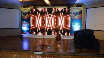 A stage with a guitar, a microphone stand, and promotional banners.