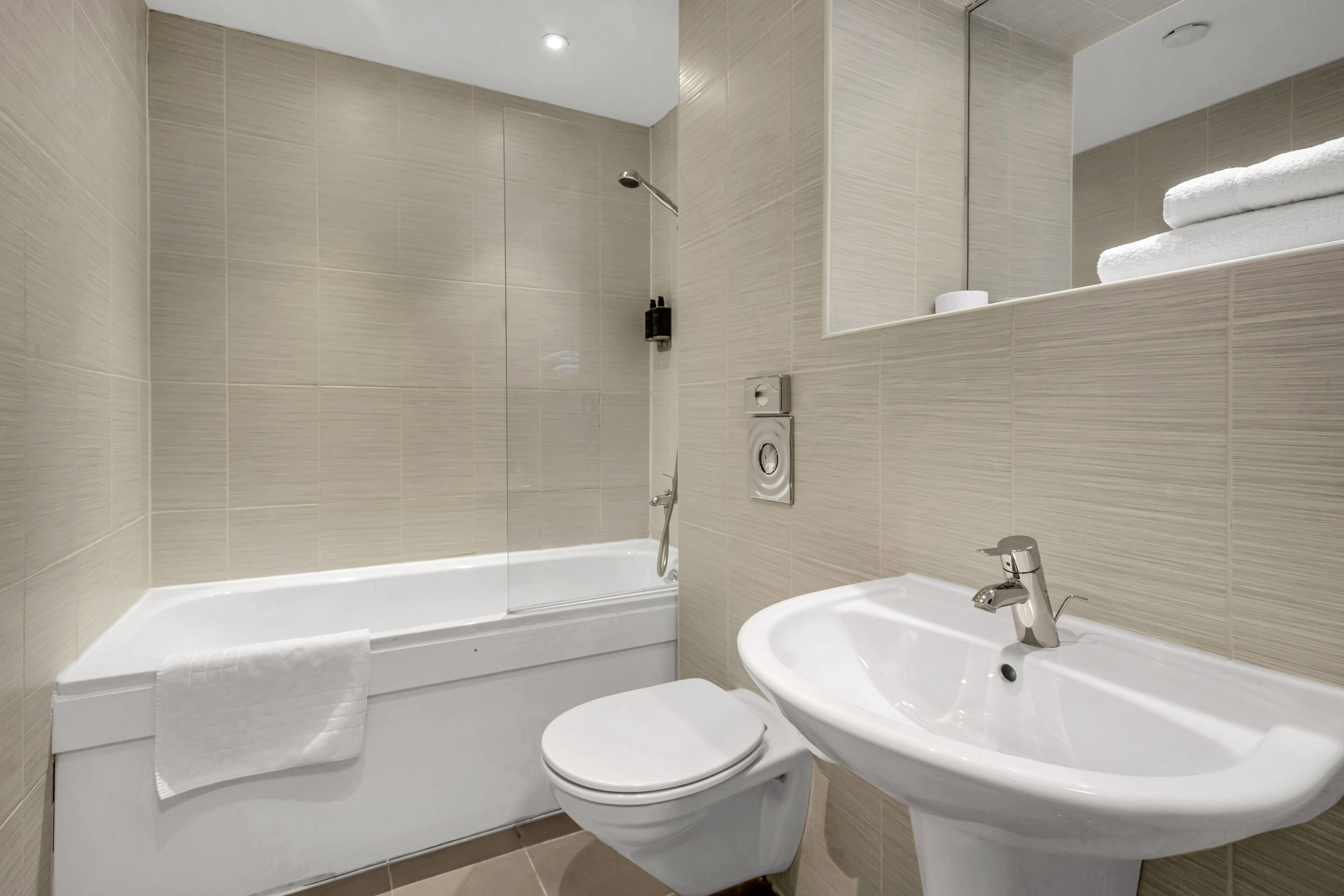 Un bagno moderno con vasca, servizi igienici e lavandino.