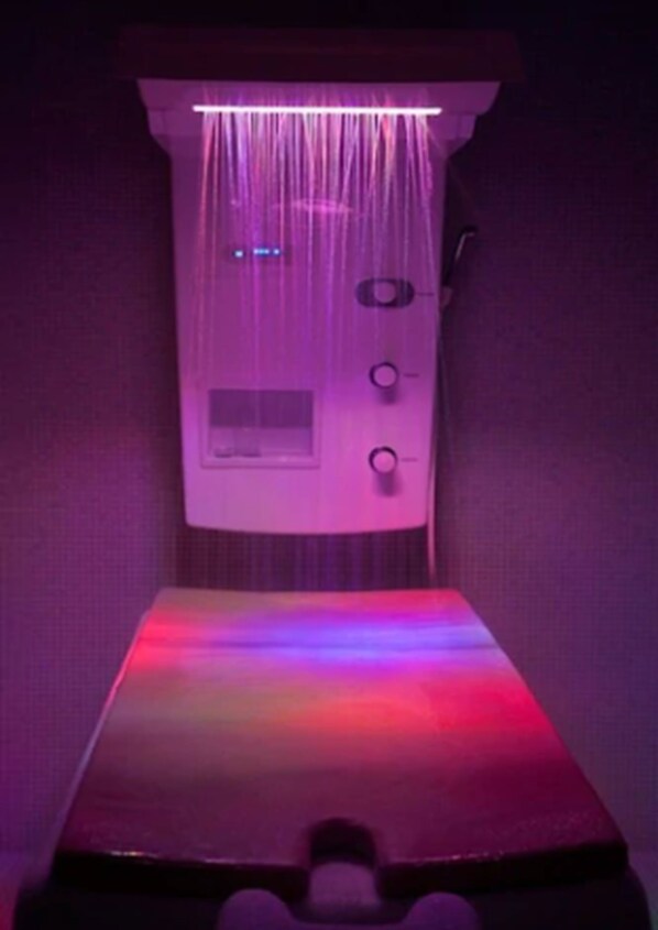 Una habitación con cama, panel de control e iluminación en el techo.