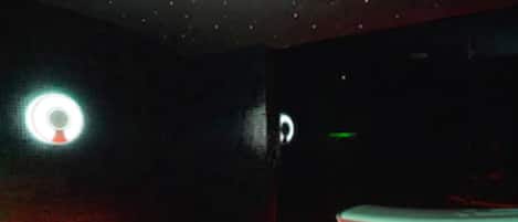 A dimly lit room with a single bed and a small table.