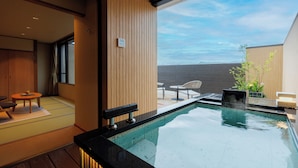 A modern indoor pool area with a view of the sky, wooden paneling, and a seating area with a table and chairs. - Tendo Onsen TAKINOYU (Tendo)