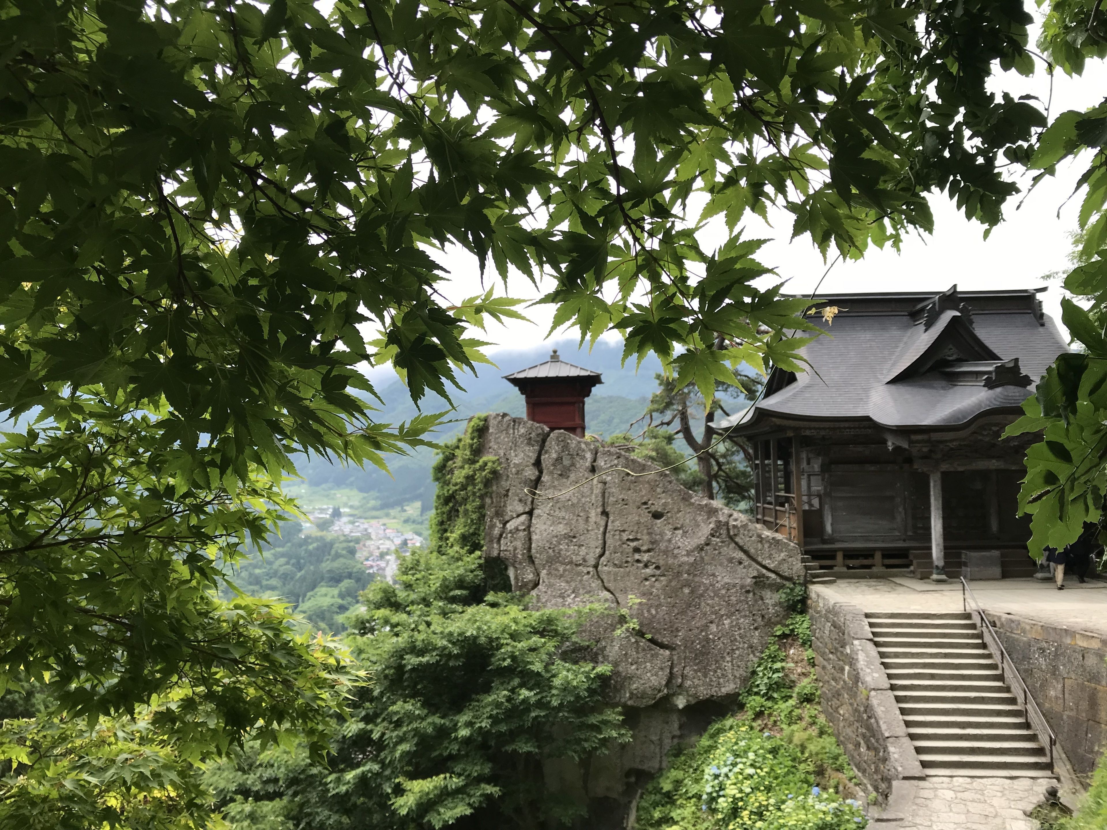 A traditional Japanese temple with a stone staircase leading up to a wooden building.