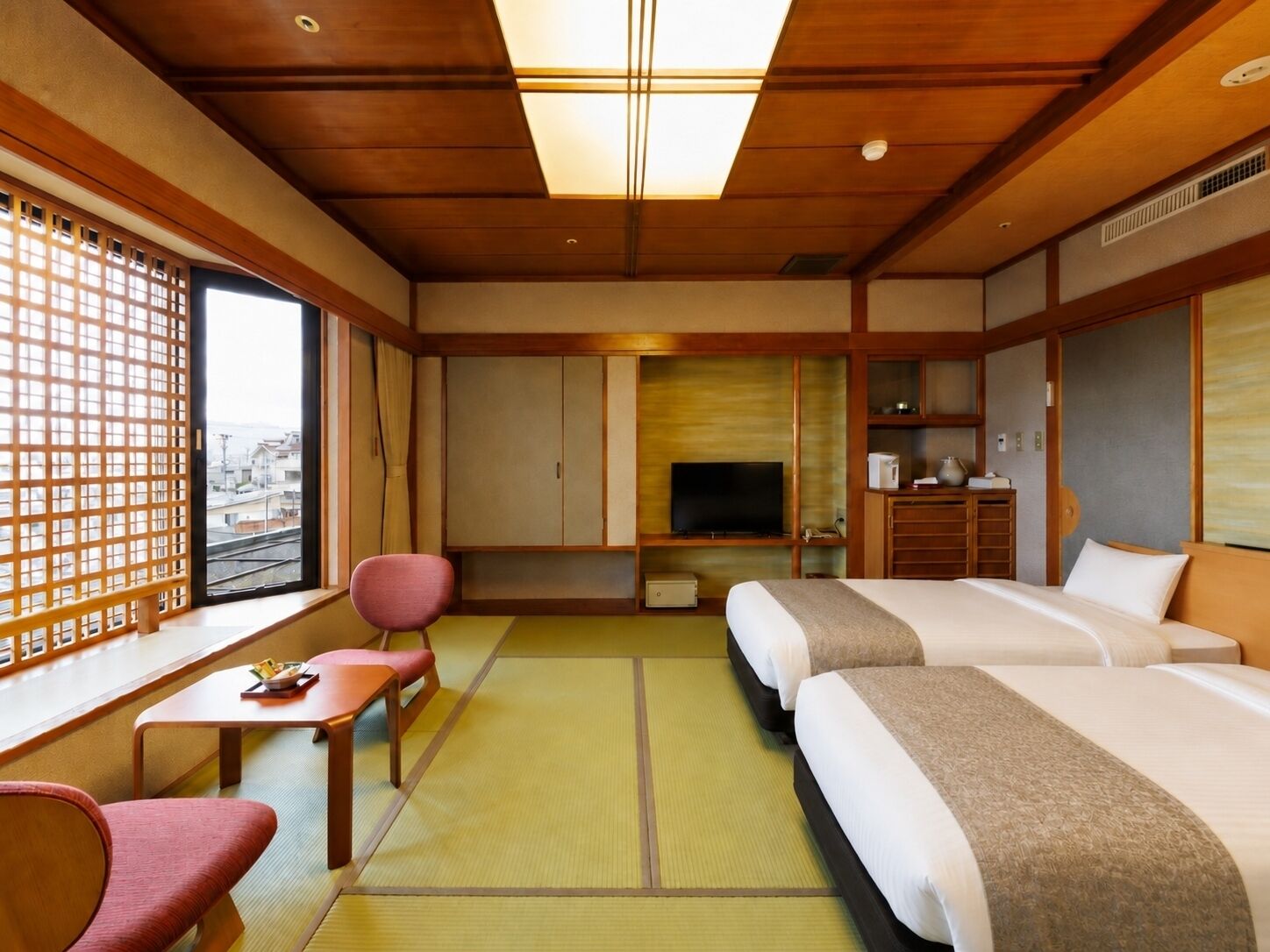 Una habitación de hotel con una cama, televisión, escritorio y silla.