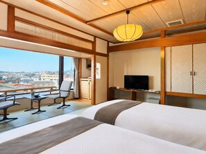 Habitación de hotel con balcón, televisión y vistas de la ciudad.