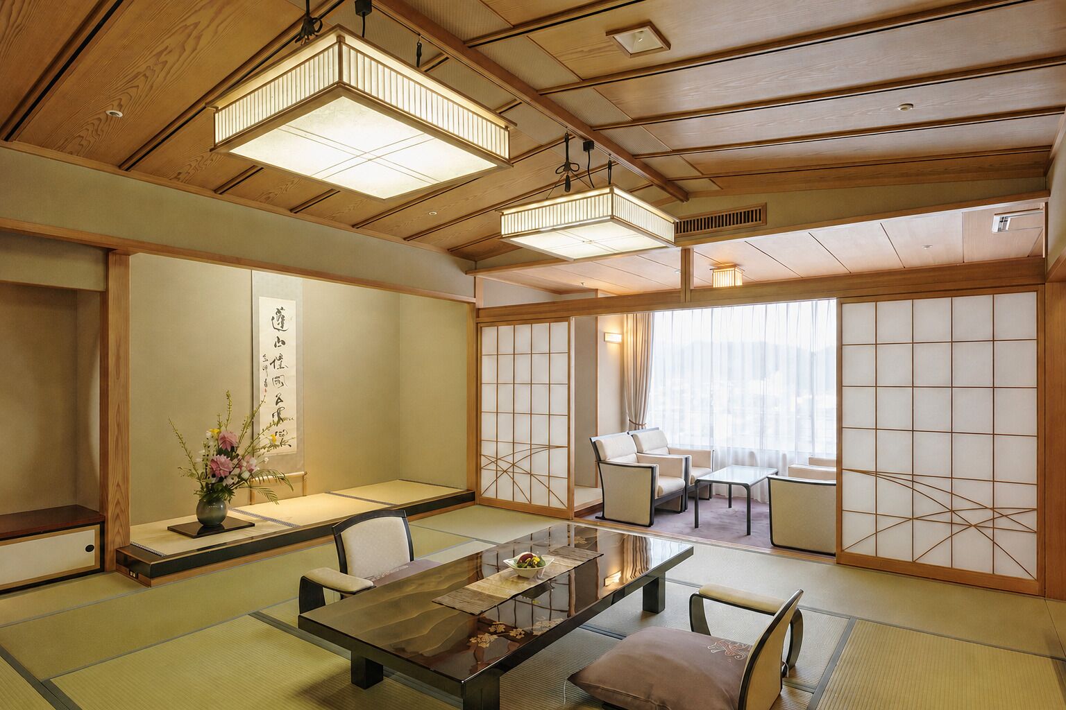 A traditional Japanese-style room with tatami flooring, low tables, and sliding doors.