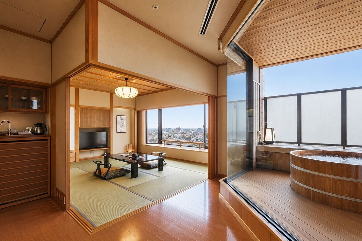Una habitación tradicional japonesa con suelo de tatami, una mesa baja de tatami, un televisor y un armario de madera.