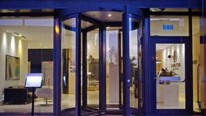 A hotel entrance with a revolving door, a reception desk, and a signboard. - DoubleTree by Hilton Hotel Girona (Girona)
