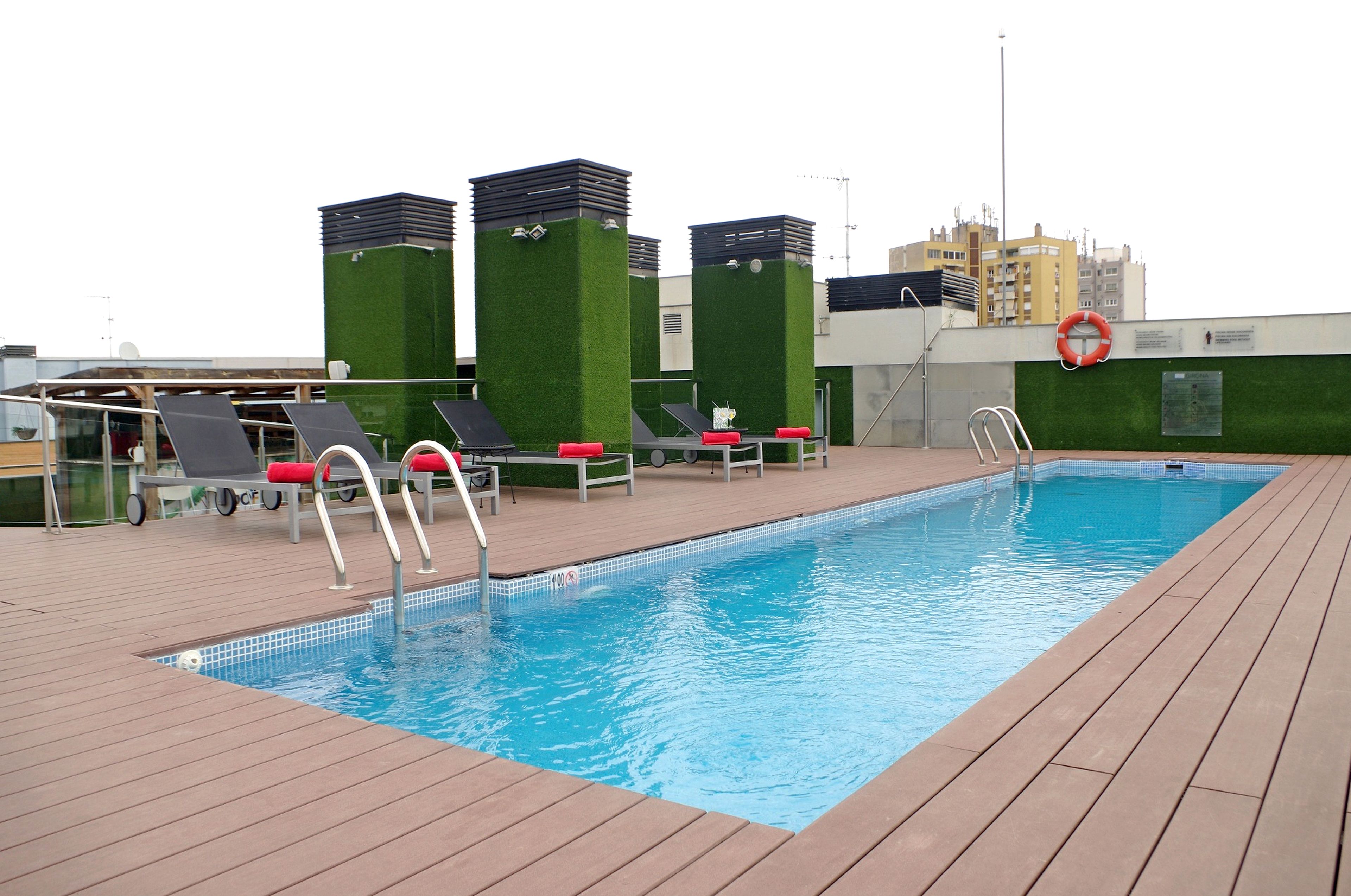 A rooftop swimming pool with sun loungers and a lifebuoy.