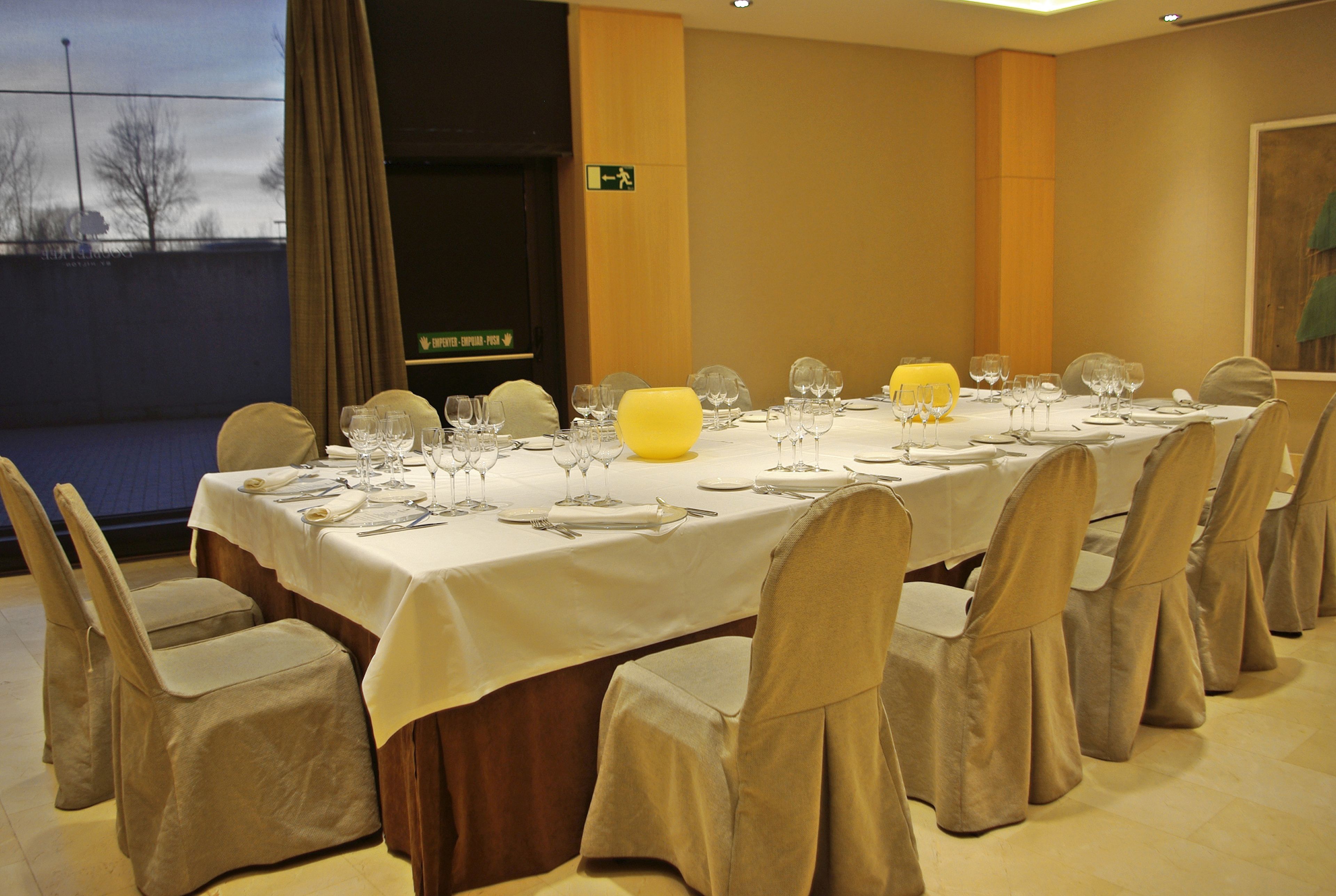 A banquet table set for a formal event, with chairs and table settings.