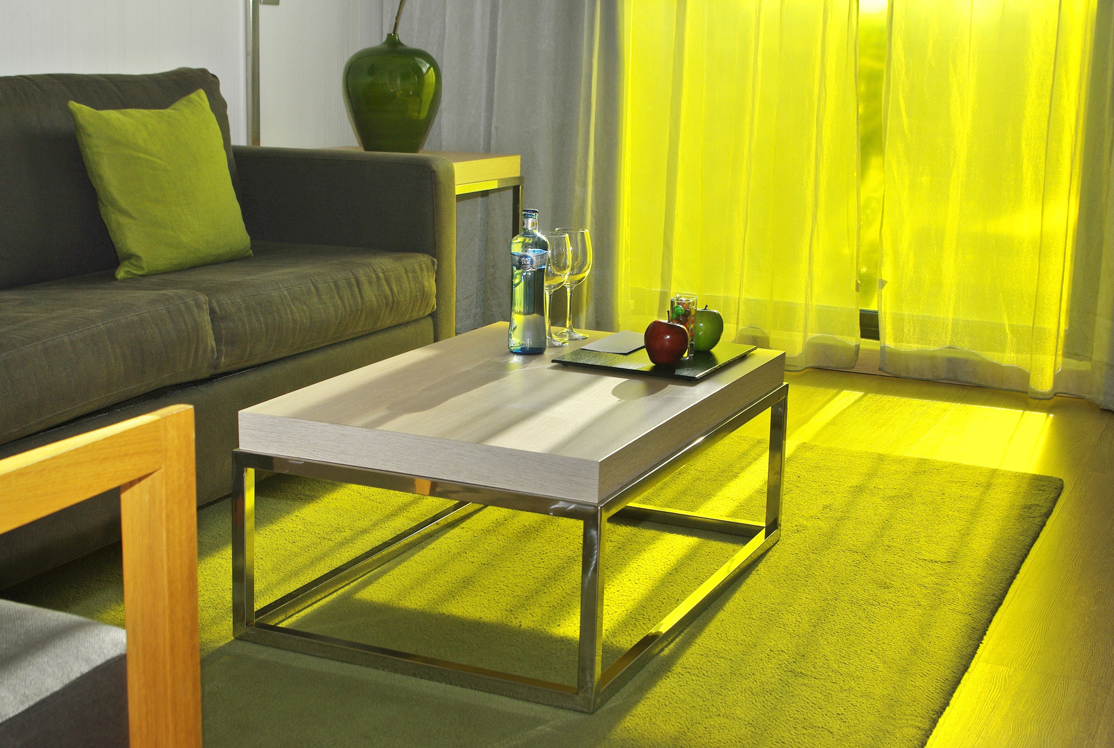 A modern living room with a sofa, a coffee table, and a dining table.