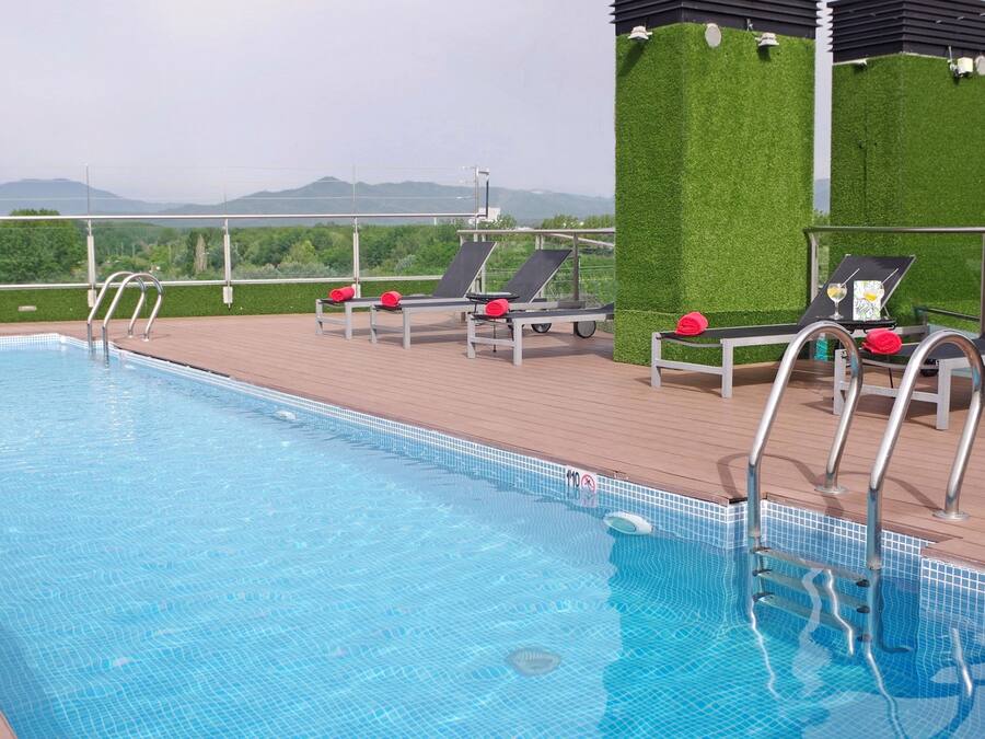A swimming pool with lounge chairs and a view of the mountains.