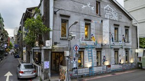 A building with a cafe sign, outdoor seating, and a street view.