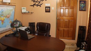 A conference room with a wooden table, a laptop, a globe, and a map on the wall.
