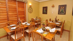 A dining area with wooden tables and chairs, decorated with floral centerpieces and tableware. - Native Abode (Crown Point)