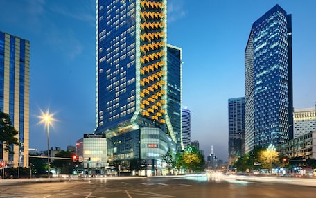 A high-rise building with a distinctive zigzag pattern on its facade, surrounded by other modern skyscrapers.
