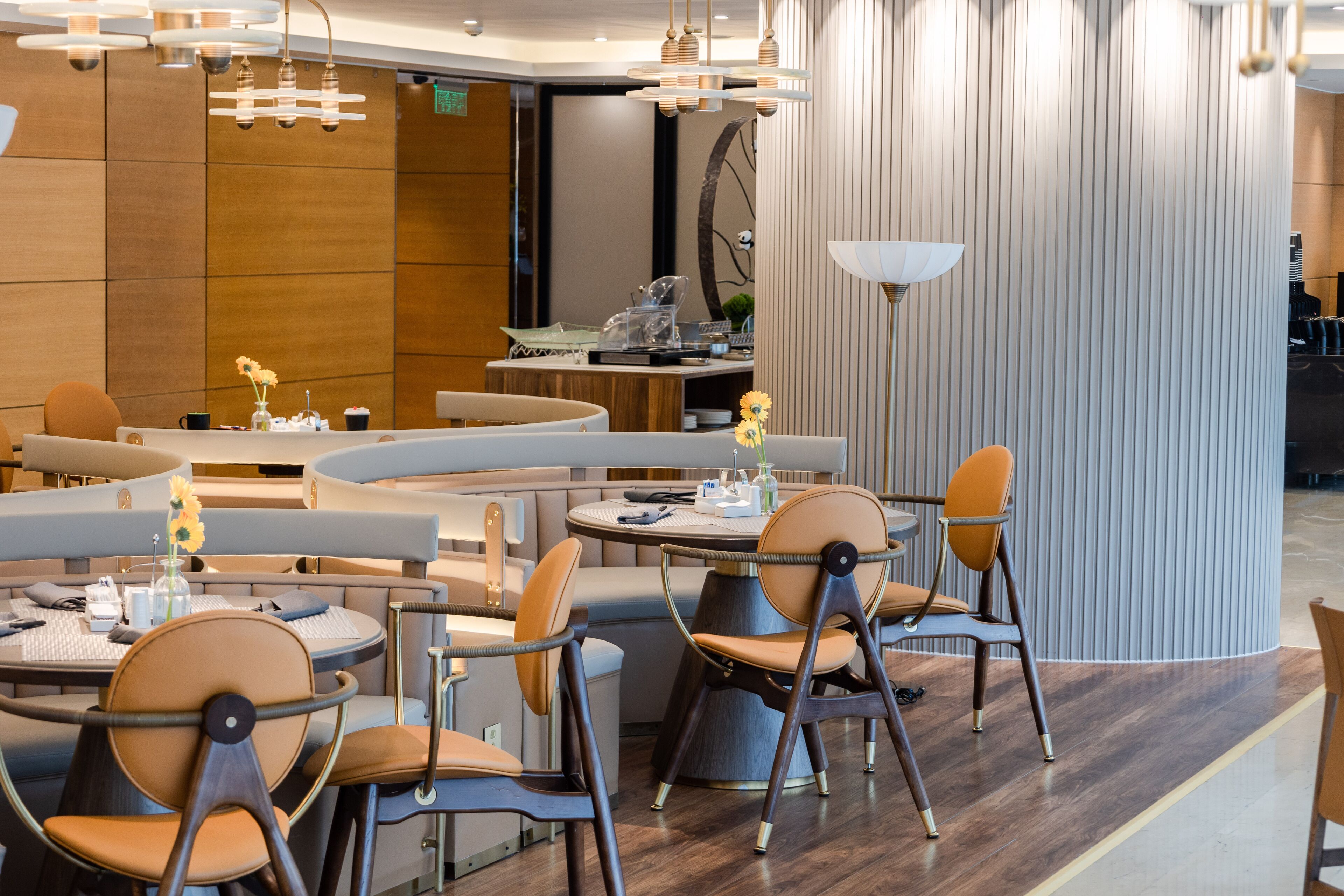 A modern restaurant with round tables and cushioned seating.