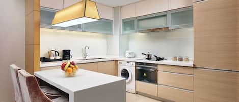 A modern kitchen with a central island, built-in appliances, and a pendant light.