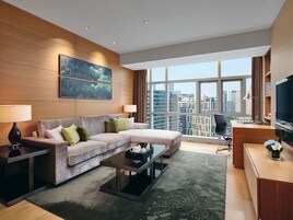A modern living room with a sofa, coffee table, and a desk with a TV.