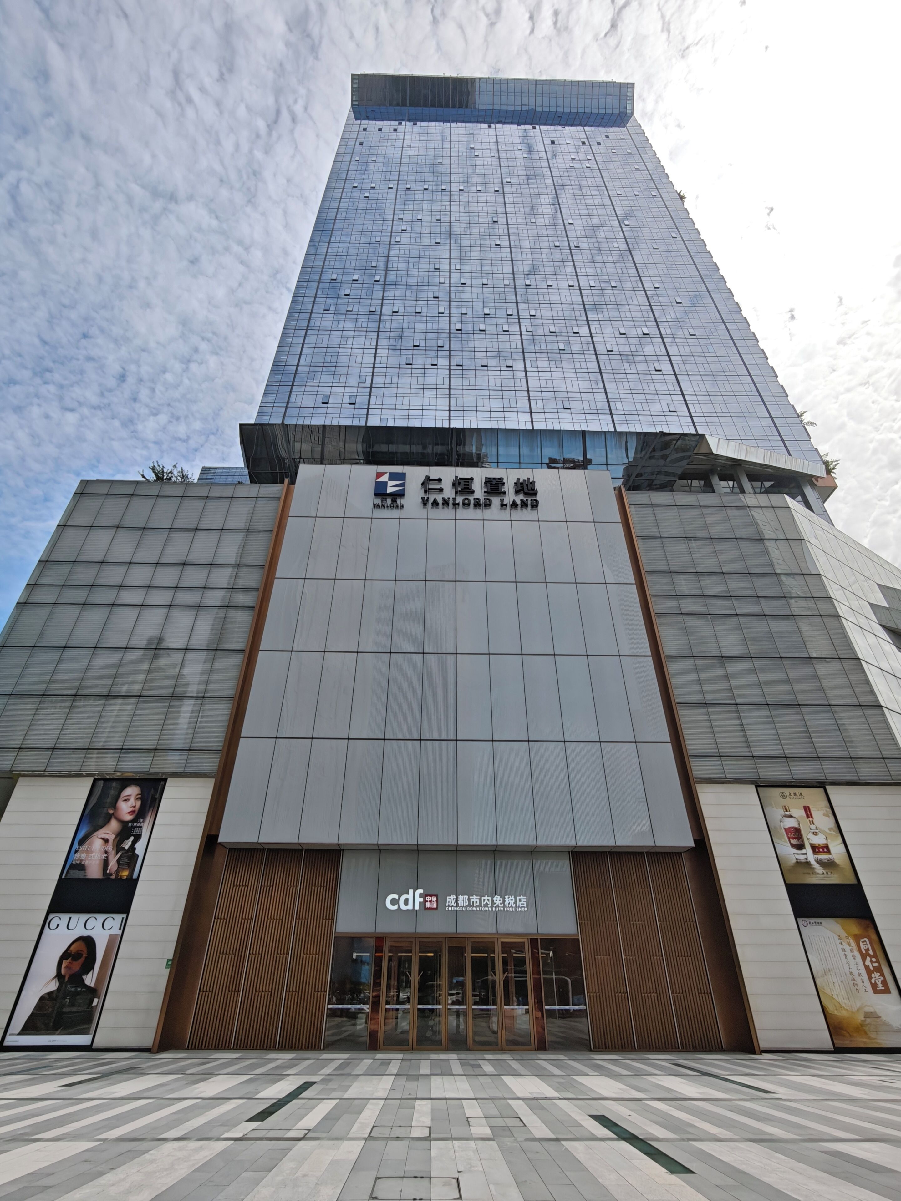 A modern building with a prominent sign for 'VANLORD LAND' and a 'cdf' sign indicating a commercial area.