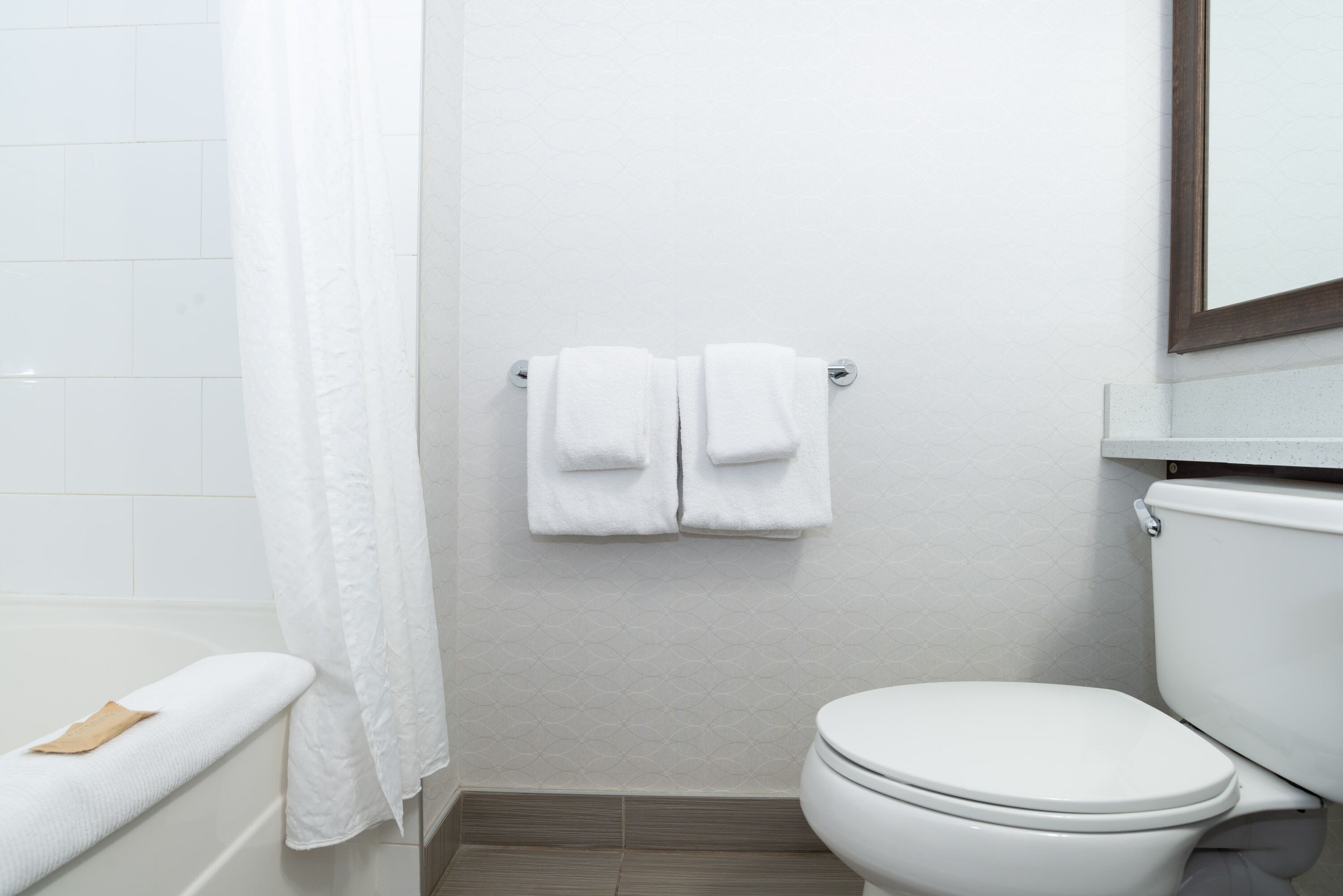 Une salle de bain équipée d’une baignoire, de toilettes et d’un porte-serviettes avec deux serviettes.