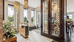 Un vestíbulo de hotel moderno con una bodega, zona de estar y grandes ventanales.