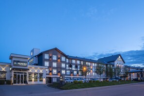 Ein Hotel mit modernem Design, das über einen großen Parkplatz und mehrere Eingänge verfügt.