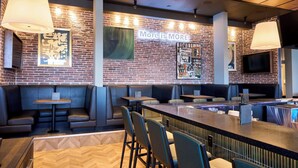 A restaurant with brick walls, a bar area, and seating arrangements.