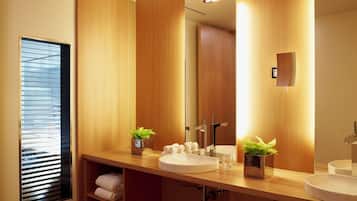 Un bagno moderno con rivestimenti in legno, due lavandini, uno specchio grande e una finestra con persiane.