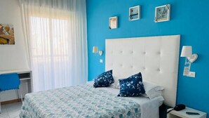 Un dormitorio con cama, escritorio y silla.