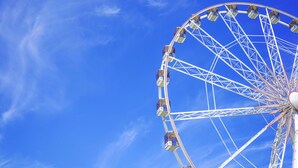 Una noria grande contra un cielo azul despejado.