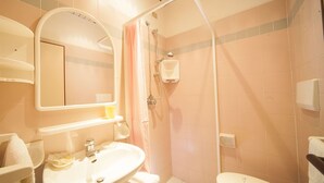 Un baño con lavamanos, inodoro y ducha.
