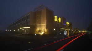 A modern hotel with a prominent vertical structure and illuminated signage. - Nanjing Vogue Boutique Motel (Nanjing)