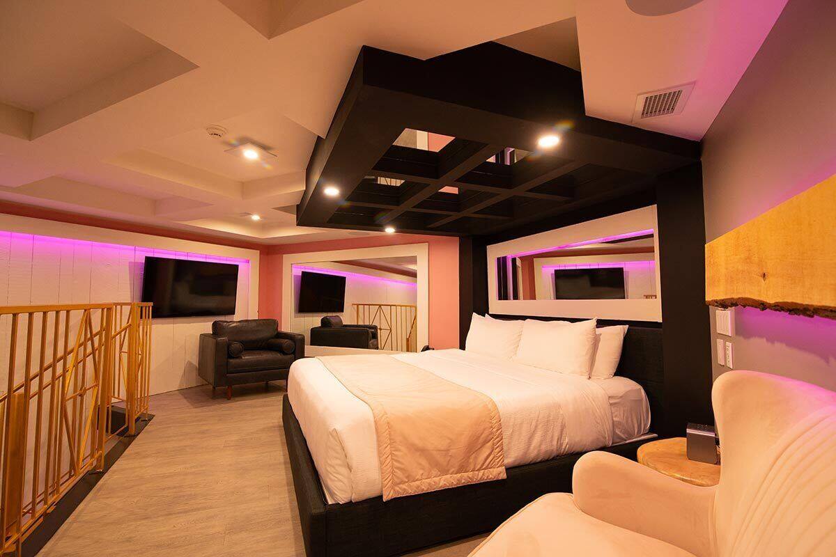 Una habitación de hotel moderna con una cama grande, un sofá y un televisor.