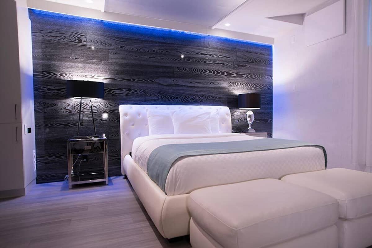 Un dormitorio moderno con una cama grande, mesitas de noche y un diseño de pared original.