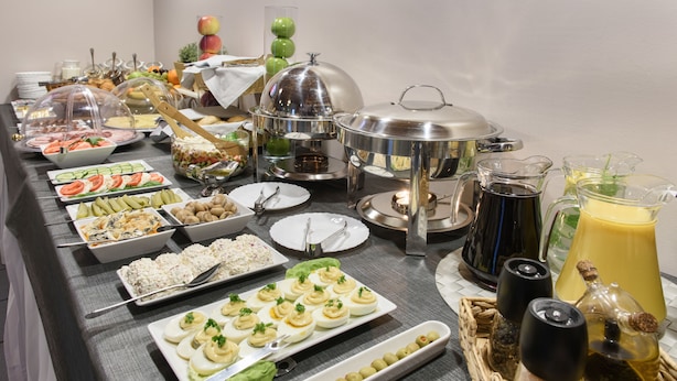 Una mesa de buffet con diversos alimentos y aderezos.
