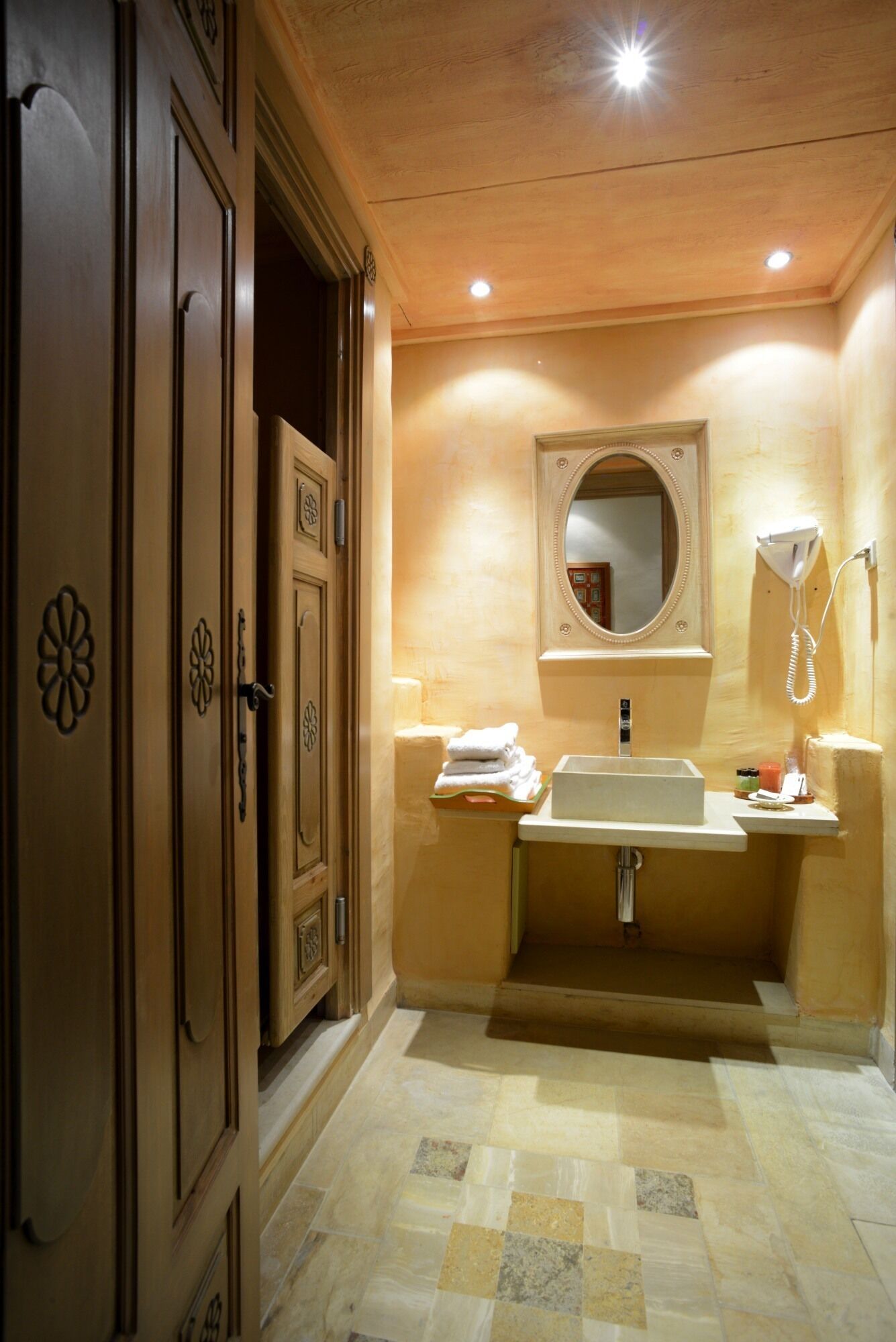 A bathroom with a wooden vanity, a sink, and a mirror.
