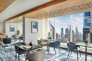 Enjoy a panoramic city view from this spacious room with a large dining area and seating space.