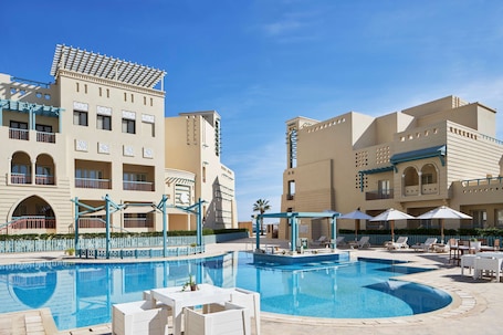 Outdoor pool, pool umbrellas, pool loungers. Mosaique Hotel - El Gouna