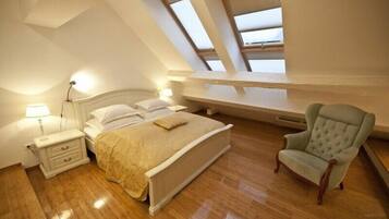 A bedroom with a bed, bedside table, lamp, and a chair.