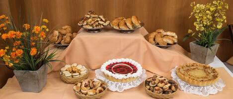 Una mesa con diversos productos horneados, como tartas y pasteles, sobre un mantel.