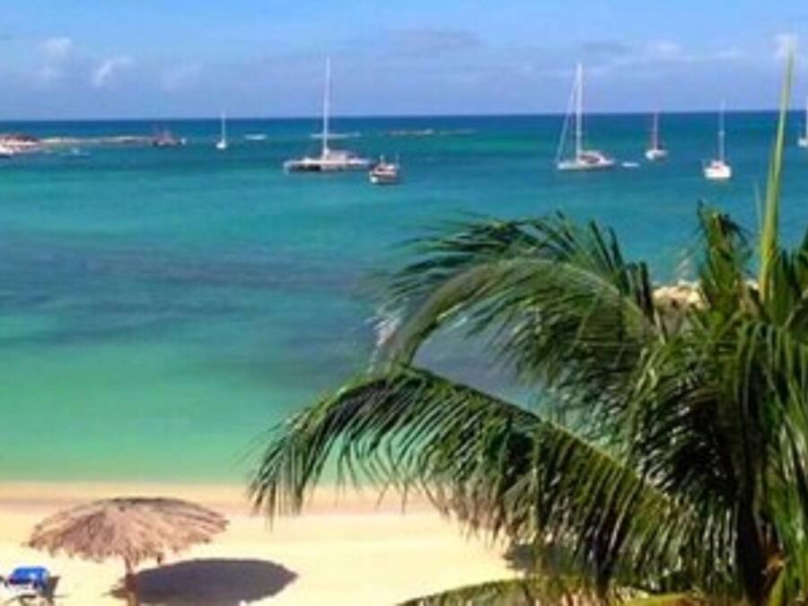 Una playa cerca, arena blanca, sillas reclinables de playa, sombrillas